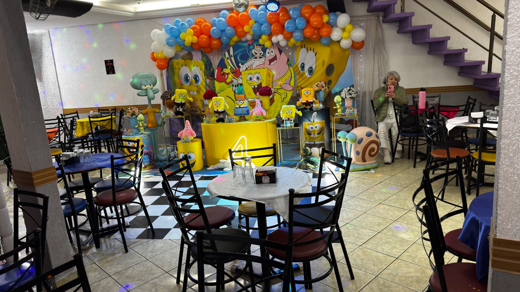 Palco da festa no salão principal do Castelo Mágico Buffet Infantil, com decoração colorida e globos