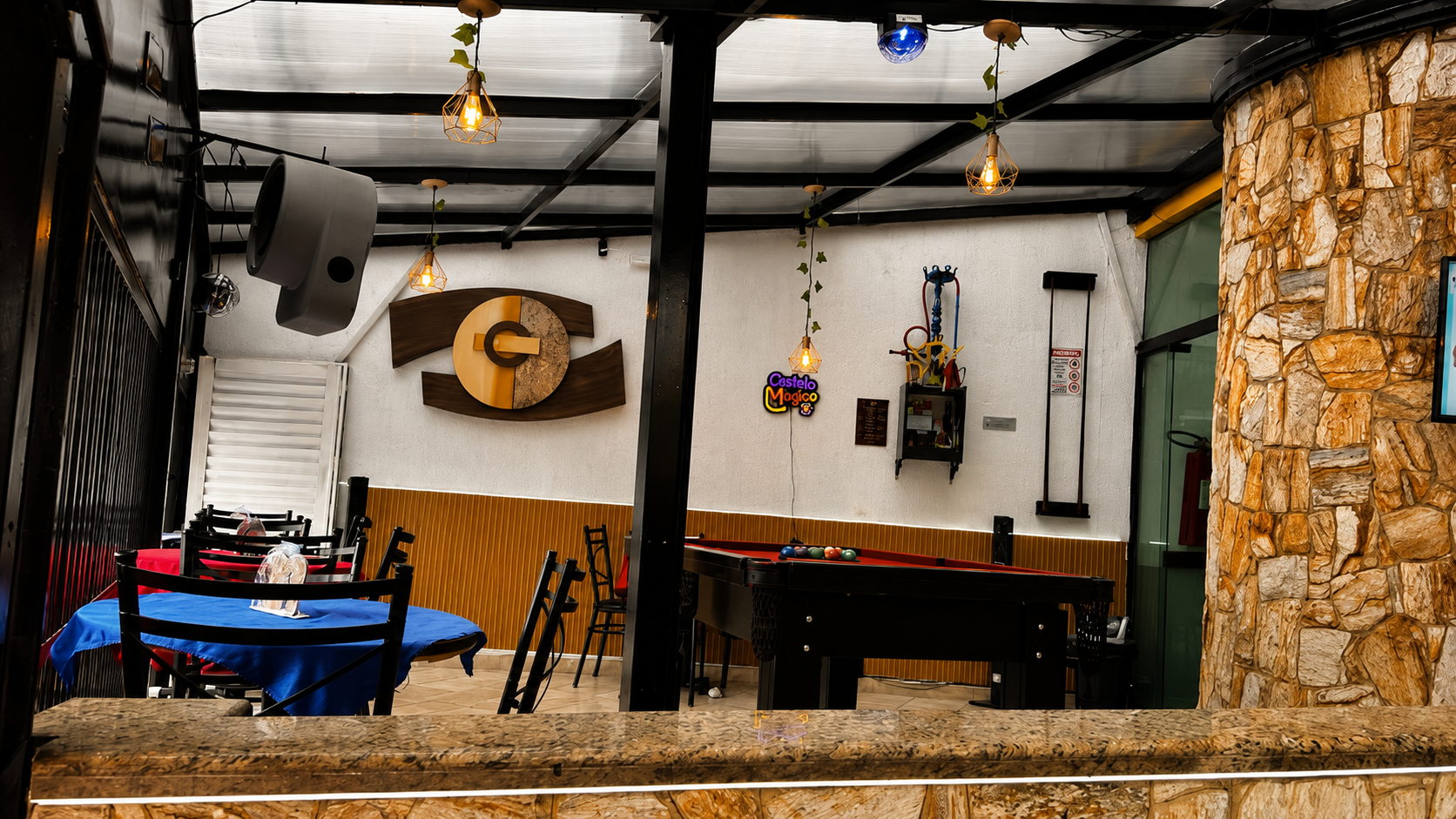 Lounge dos adultos do Castelo Mágico Buffet Infantil, com mesa de sinuca, mesa azul e letreiro neon do Castelo Mágico